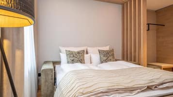 Un dormitorio moderno con cama, almohadas, una mesita de noche y una lámpara.