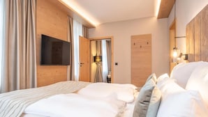 Una habitación de hotel con cama, cortinas, televisor y lámpara.