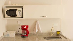 Et tekøkken med mikroovn, kaffemaskine, vask og et 'Welcome'-skilt over mikroovnen.