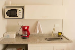 A kitchenette with a microwave, coffee maker, sink, and a 'Welcome' sign above the microwave. - Apartment in Jardins with parking space and pool. (São Paulo)