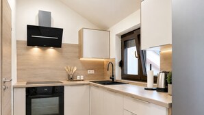 Eine moderne Küche mit eingebauten Geräten, einem Fenster und einer Holzrückwand.