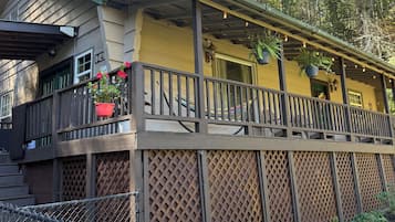 A two-story building with a balcony, a wooden fence, and a garden area.
