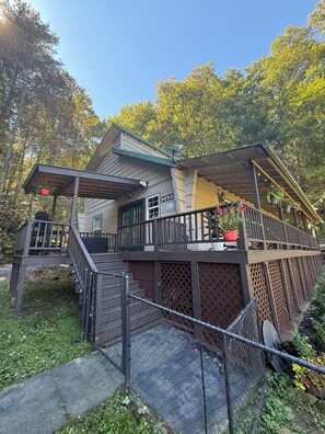 A two-story house with a covered porch, a fenced deck, and a number '145' sign.