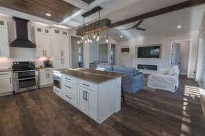 A modern kitchen with white cabinets, a central island, and stainless steel appliances. - Coastal Retreat with Private Pool in Historic Saint Augustine Florida (St. Augustine)