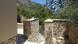 Una pared de piedra con una escalera de piedra que sube a un nivel superior.