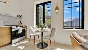 Uma cozinha moderna com área de jantar, grandes janelas e vista para o céu.