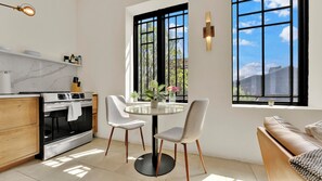 Uma cozinha moderna com área de jantar, grandes janelas e vista para o céu.