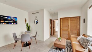 Uma sala de estar moderna com televisão, área de jantar e uma porta de madeira.