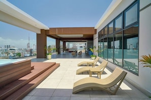 A rooftop terrace with a pool, lounge chairs, and a view of the city skyline. - ®{2BR | Urban~Oasis} DowntownSD +Pool+Gym+Balcony (Santo Domingo)