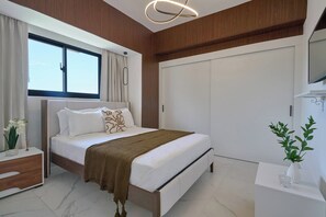 Een moderne slaapkamer met een bed, nachtkastje en een groot raam.
