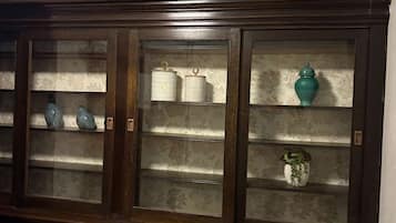 Un mueble de madera oscura con puertas de cristal y varios estantes.
