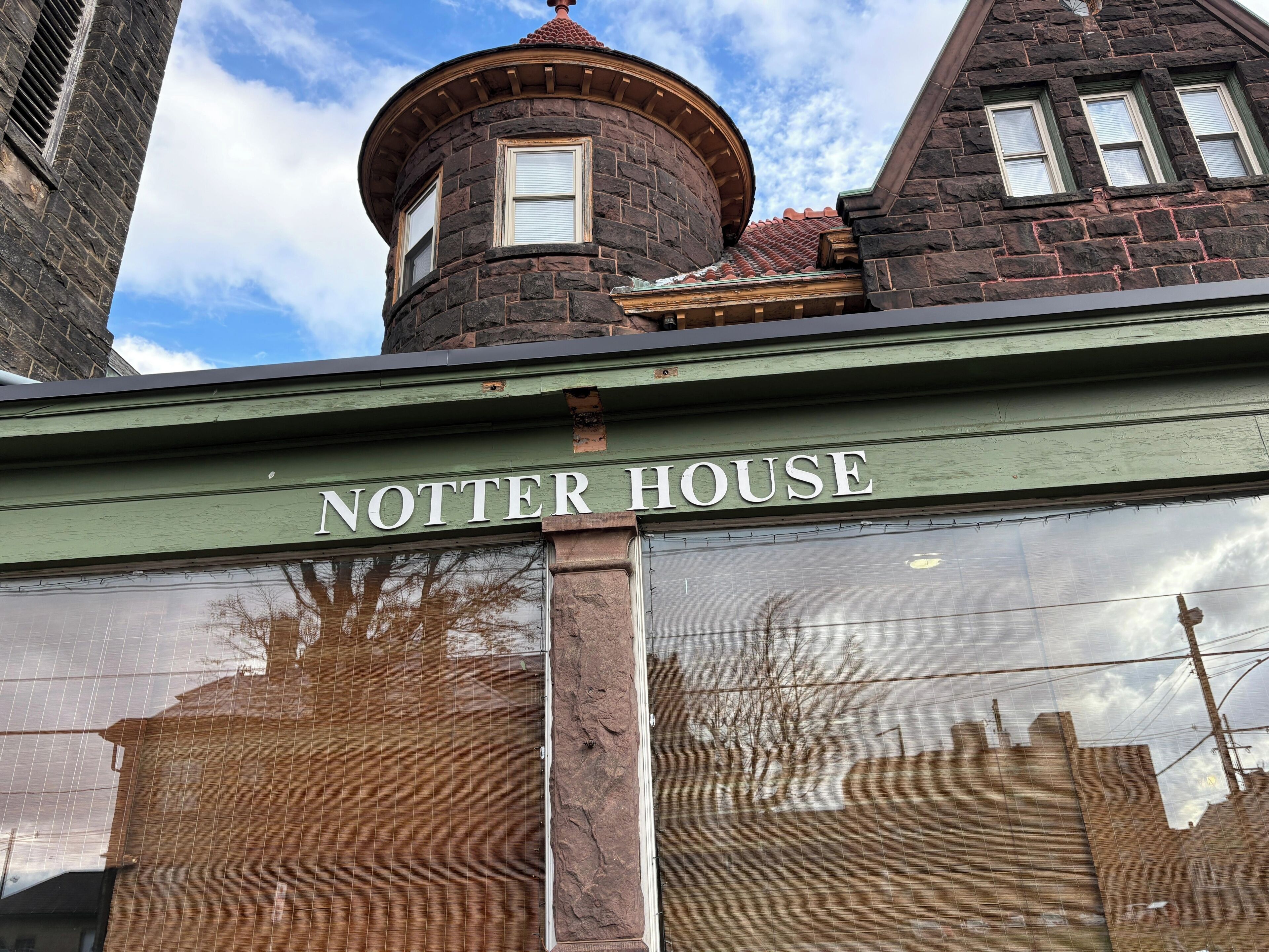 Um edifício com uma fachada de tijolos e uma placa indicando 'NOTTER HOUSE'.
