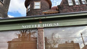 Um edifício com uma fachada de tijolos e uma placa indicando 'NOTTER HOUSE'.