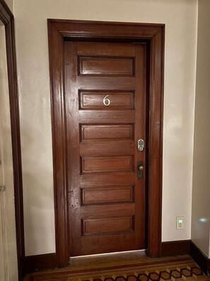 A wooden door with a number '6' and a keypad lock.