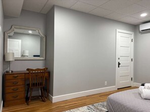 A bedroom with a wooden desk, a chair, a bed, and a white door. - NH6 - Modern 2BR Retreat in a Historic House (DuBois)