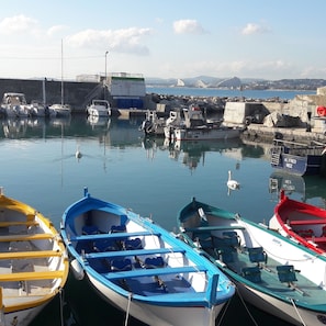 A harbor with various boats docked, including a yellow and a blue rowboat. - Air-conditioned 2-room apartment with a terrace, a 3-minute walk from the beach and restaurants (Cagnes-sur-Mer)