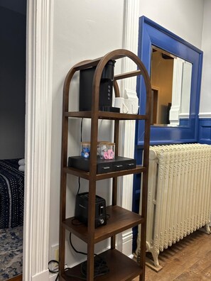 Une étagère en bois contenant des appareils électroniques et des boîtes de rangement.