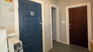 A laundry room with a blue door, a washing machine, and a dryer. - DM-A Historic 2BR Apartment (DuBois)