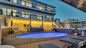 Ein modernes Haus mit Pool, Außenbar und Lounge-Bereich.