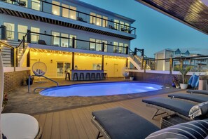 Ein modernes Haus mit Pool, Außenbar und Lounge-Bereich.