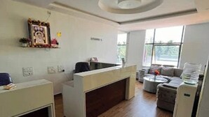 Un área de recepción con mostrador, sofá y máquina de café.