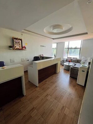 A reception area with a desk, a couch, and a coffee machine.