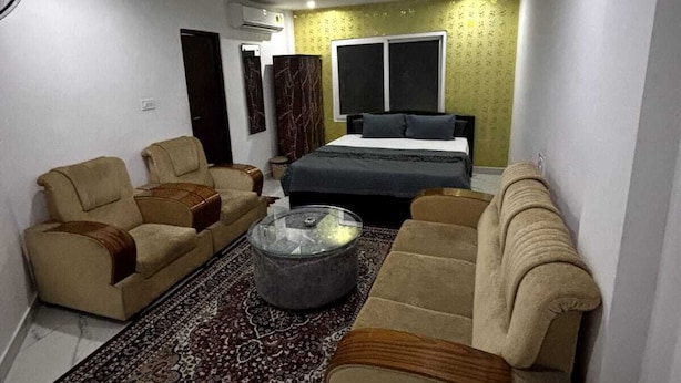 Un espacio habitable pequeño con un sofá, una mesita de centro y una cama.