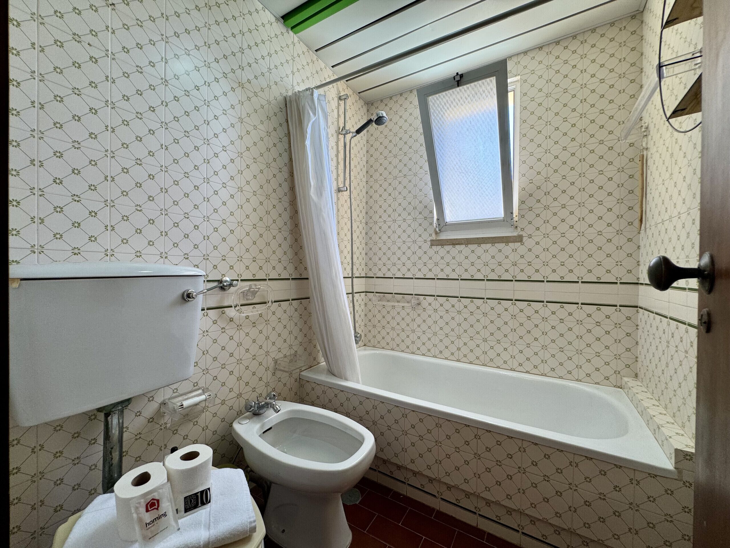 A bathroom with a toilet, bidet, and bathtub.