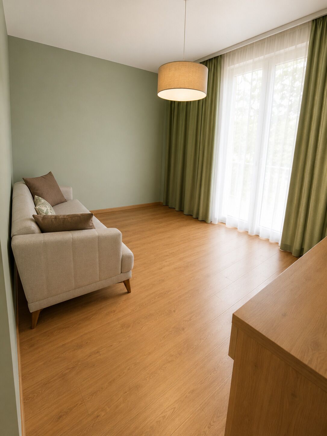 Una sala de estar minimalista con un sofá, una mesa de centro de madera y cortinas traslúcidas.