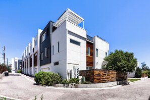 A modern multi-story building with a flat roof, large windows, and a mix of white and dark facade materials. - Sloan's Lake Luxury | Private Rooftop | 30-Day Min (Denver)