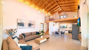 A spacious living area with a high ceiling, a dining area, and a kitchen. - Orientem Villa Heated Pool (Nippos)