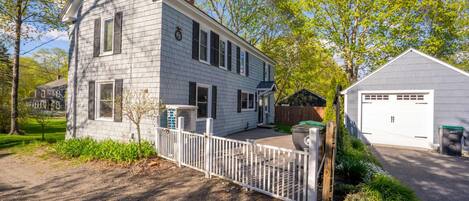 A two-story house with a white exterior, a front porch, and a garage.
