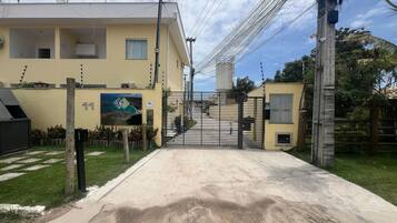Uma entrada fechada por portão para um edifício, com uma placa indicando o nome 'CORAIS'.