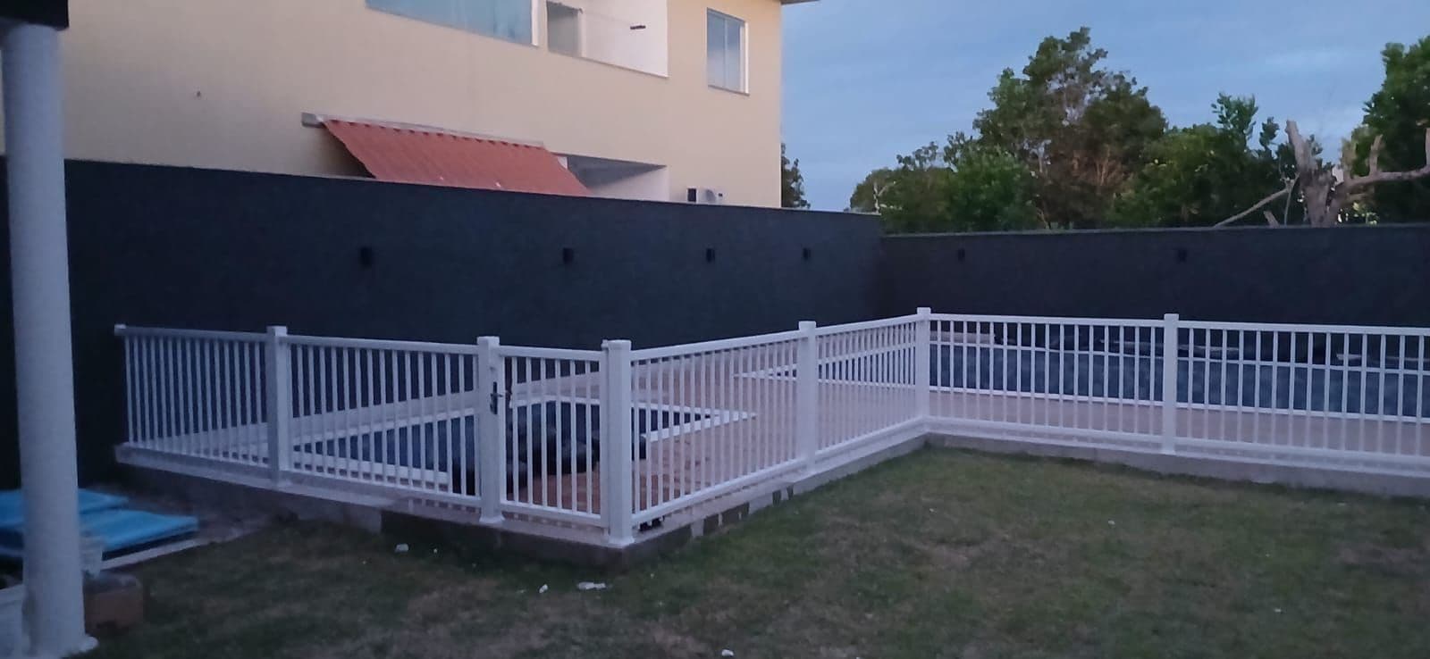Un espacio exterior cercado con un edificio al fondo.