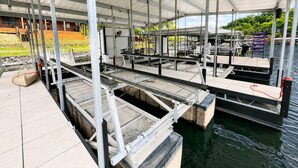 Un espacio al aire libre cubierto con estructuras metálicas, un muelle y una masa de agua.