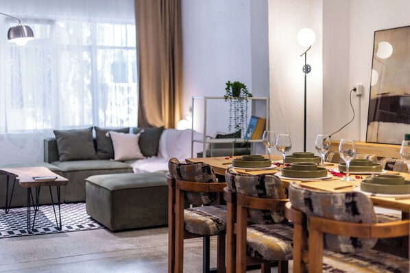 A modern living room with a dining area, a sofa, a coffee table, and a floor lamp.