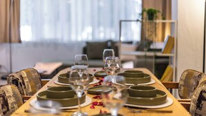 Een eettafel gedekt met borden, glazen en een kaars.