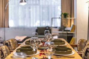 A dining table set with plates, glasses, and a candle.