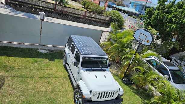 A white SUV parked on a grassy lawn with a basketball hoop and palm trees in the background. - Spacious Family-Friendly Kings Park Retreat Sleeps 6+ 3BR/3BA A/C, WiFi & Parkin (Belize City)