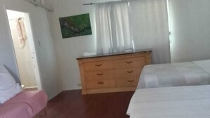 A room with a bed, a dresser, a chair, and a painting on the wall. - Spacious Family-Friendly Kings Park Retreat Sleeps 6+ 3BR/3BA A/C, WiFi & Parkin (Belize City)