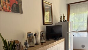 A kitchen with a wooden countertop, a TV, a refrigerator, and a window with a view of greenery. - Cozy, quiet for families. Pets allowed (Perugia)
