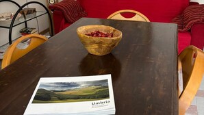 A dining table with a bowl and a brochure, a red sofa, and a framed picture on the wall. - Cozy, quiet for families. Pets allowed (Perugia)