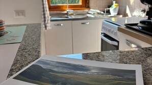 A kitchen with a window, a book titled 'Umbria,' and a view of trees outside. - Cozy, quiet for families. Pets allowed (Perugia)