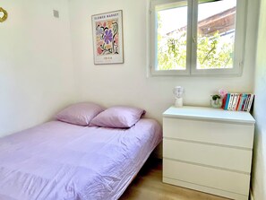 A bedroom with a bed, a dresser, a window, and a poster on the wall. - Magnificent, peaceful ground floor villa with unobstructed view. Ideal for families (Sainte-Maxime)