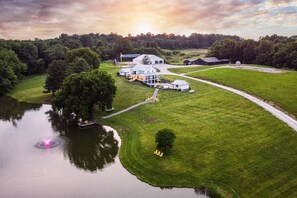 A large estate with a lake, multiple buildings, and a well-maintained lawn.