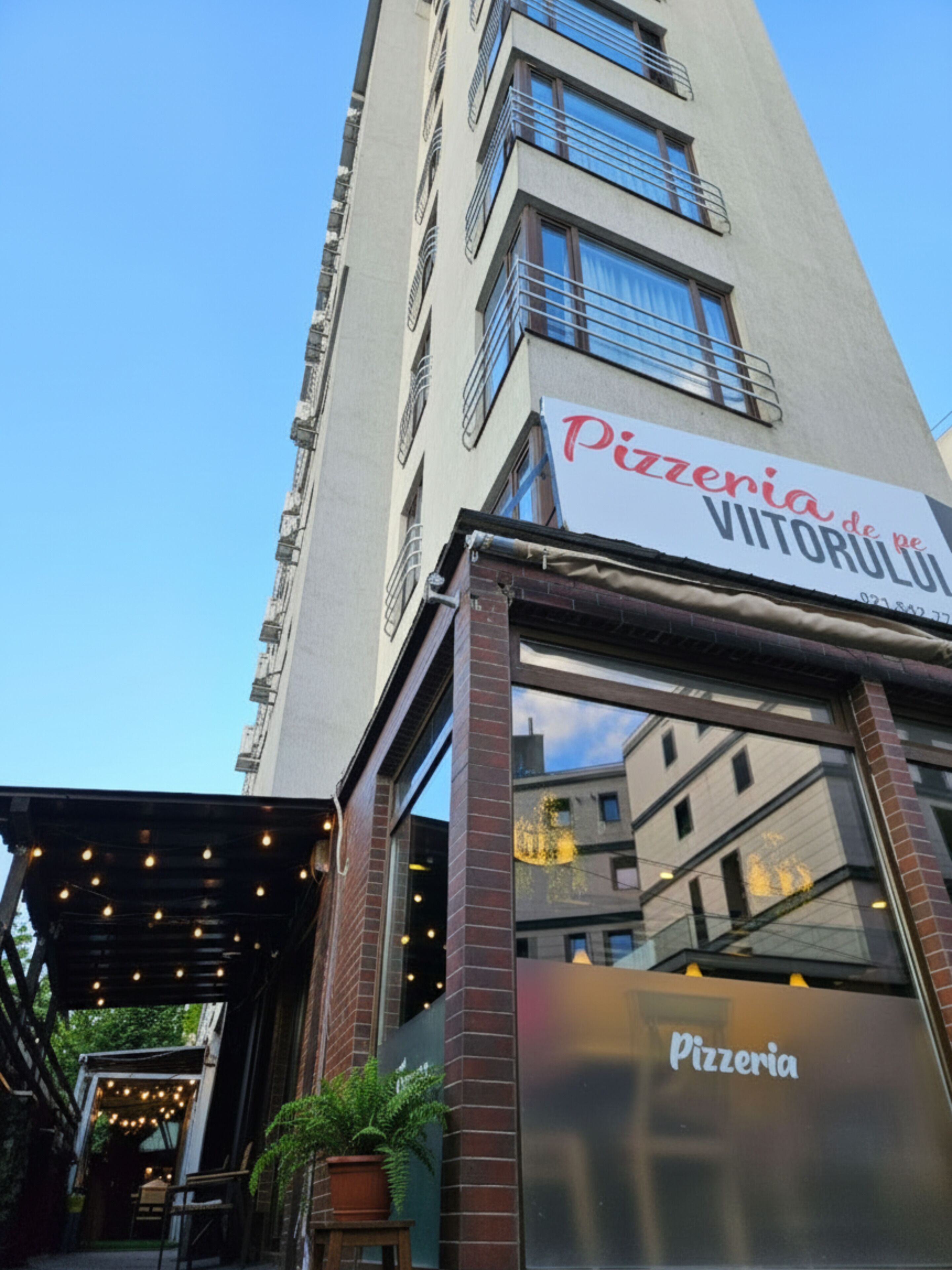Un bâtiment dont la façade porte une enseigne indiquant « Pizzeria de pe Vitoriului ».