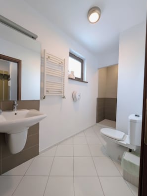 Ein Badezimmer mit Waschbecken, Toilette und einem Fenster.