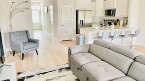 A modern kitchen with white cabinets, a stainless steel refrigerator, and a microwave. - San Destin Dream Vacation 3-bedroom townhome in beautiful Santa Rosa Beach. (SANTA RSA BCH)