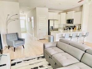 A modern kitchen with white cabinets, a stainless steel refrigerator, and a microwave. - San Destin Dream Vacation 3-bedroom townhome in beautiful Santa Rosa Beach. (SANTA RSA BCH)