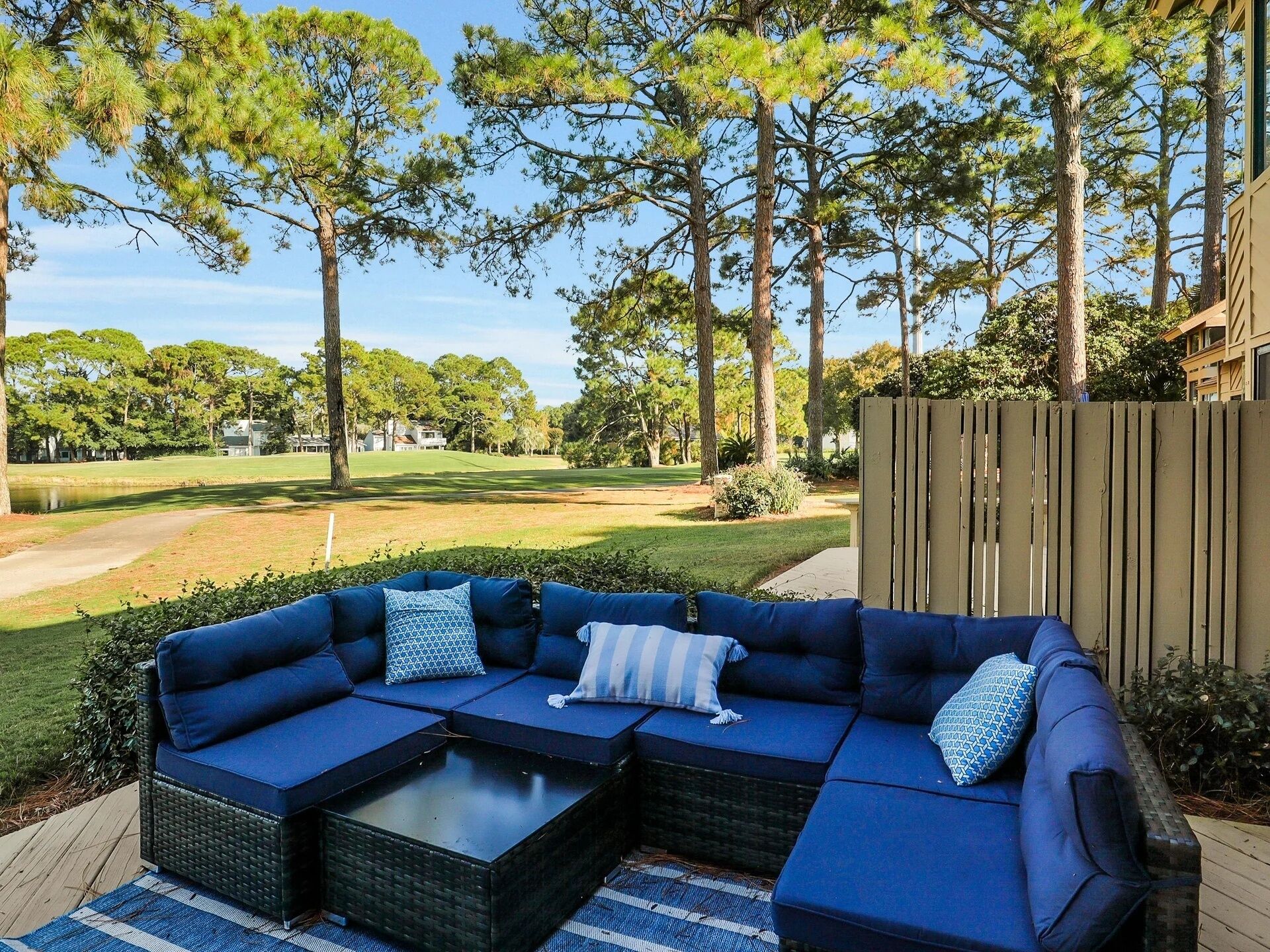 A sectional sofa with cushions, a coffee table, and a wooden deck.